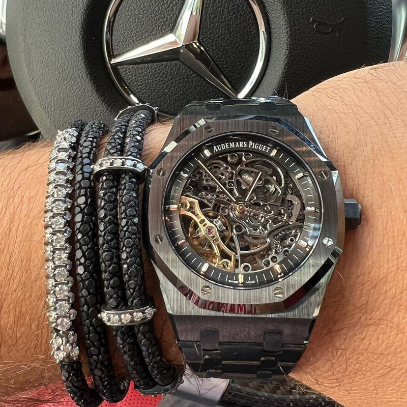 StingHD bracelet inspired by ancient Roman gladiators, featuring black platinum-plated silver columns with 25 glistening diamonds, bound by black stingray leather cords, elegantly showcased by (IG: SPJeweler).